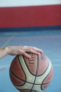 Foto de baloncesto que recoge la acción del bote con una mano abierta con los dedos cómodamente extendidos y relajados situada encima del balón