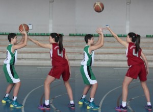 Foto de baloncesto que recoge a una niña defendiendo a un niño que no ha botado, golpeando el balón hacia arriba en la defensa del hombre con balón