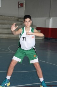 Foto de baloncesto de un niño en posición básica defensiva usando un antebrazo en una posición de 90º en la defensa del hombre con balón