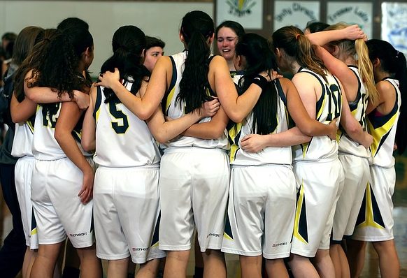 Fotografía de baloncesto que recoge a un equipo femenino con sus jugadoras juntas y abrazadas