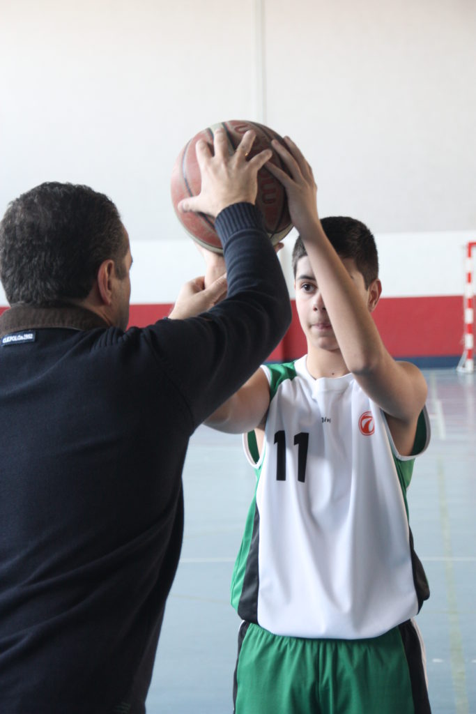 Foto de baloncesto que recoge la enseñanza del tiro de un entrenador a un niño